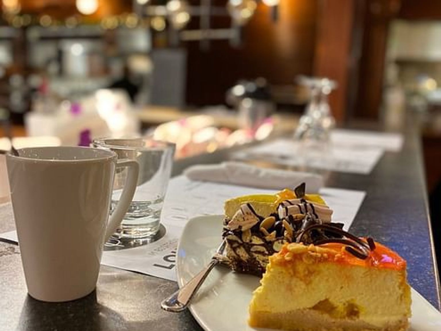 a slice of cheesecake is on a plate next to a cup of coffee