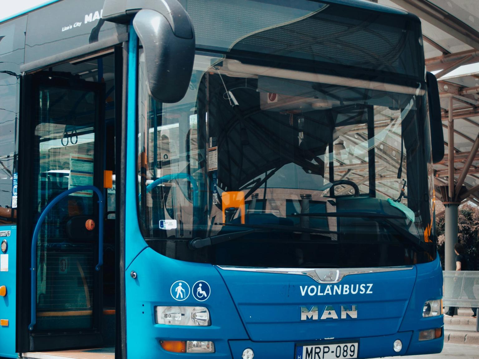 en blå mann volanbusz buss er parkert foran en bygning