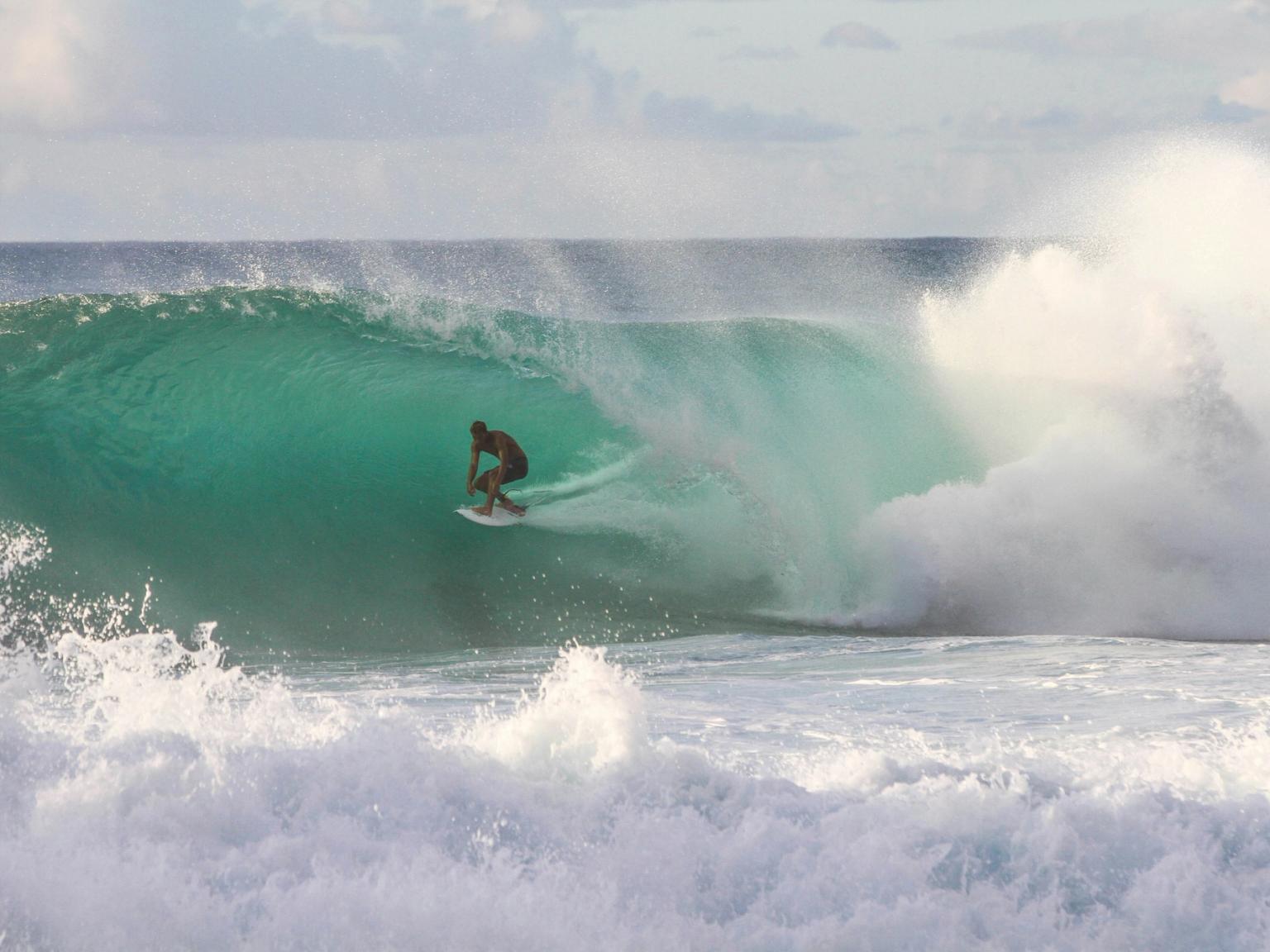 a man is riding a wave on a surfboard in the ocean.