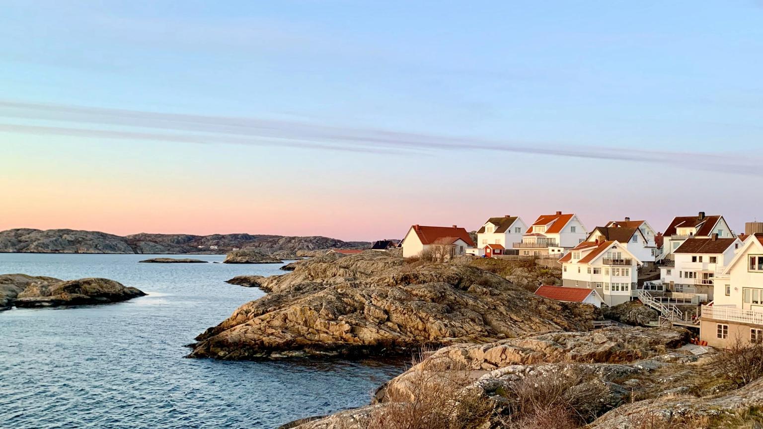 en rad hus på en klippig klippa med utsikt över havet