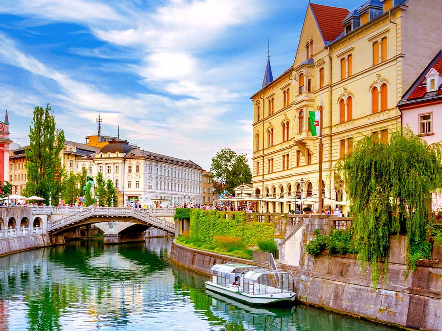 en båt flyter på en flod i mitten av en stad