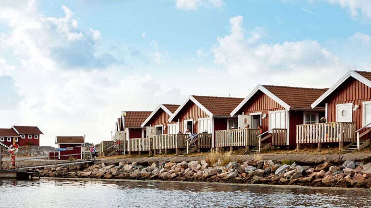 en rekke røde hus ved siden av et vann