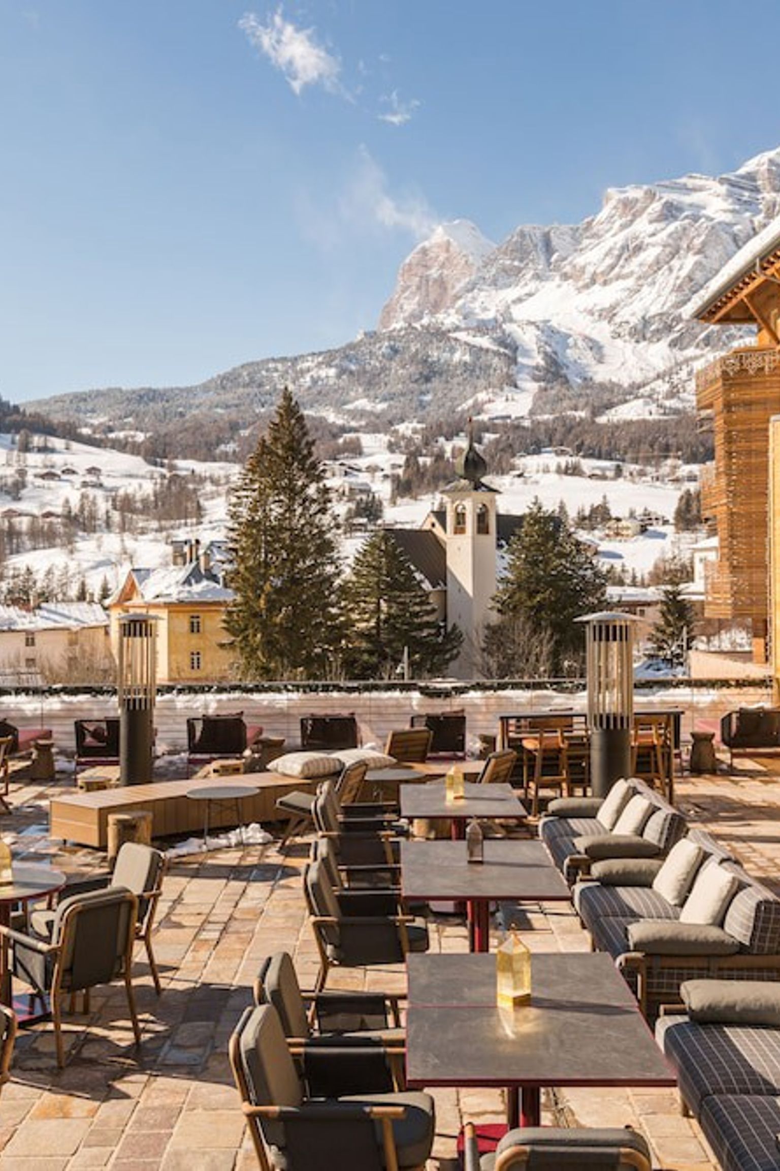 en uteplass med bord og stoler foran en bygning med et fjell i bakgrunnen, Grand Hotel Savoia Cortina d'Ampezzo, A Radisson Collection Hotel