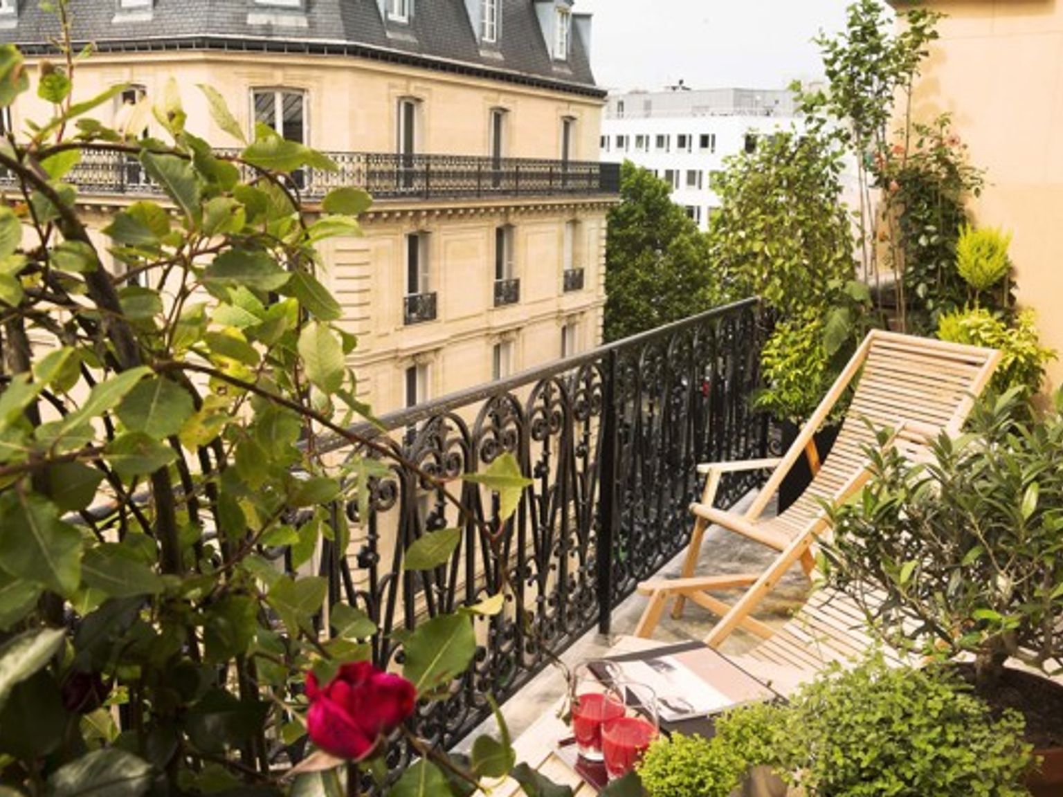 det er en balkong med en stol og blomster på den