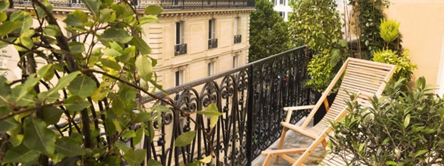 det er en balkong med en stol og blomster på den