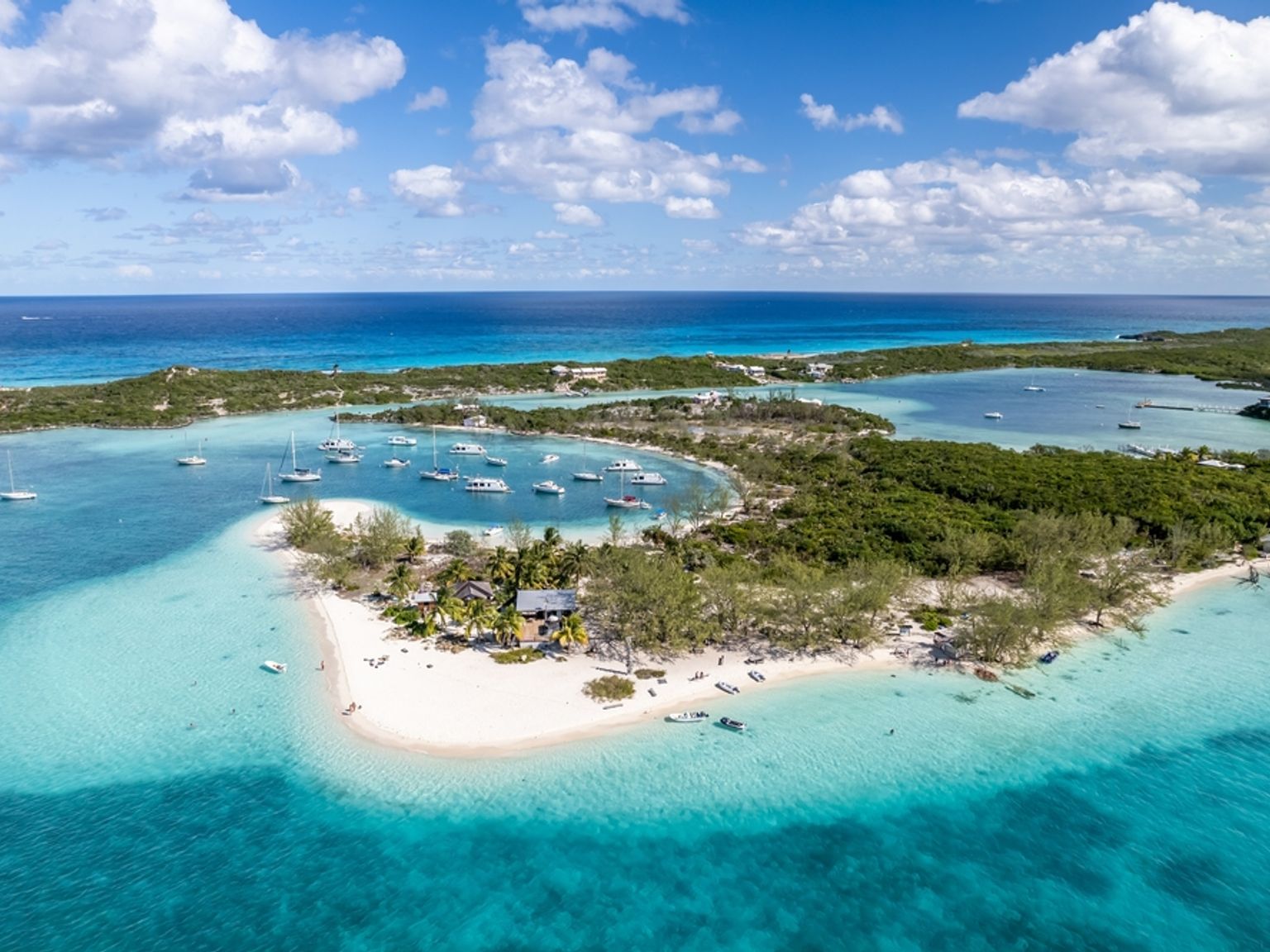 en flygbild av en liten ö mitt i havet med båtar i vattnet