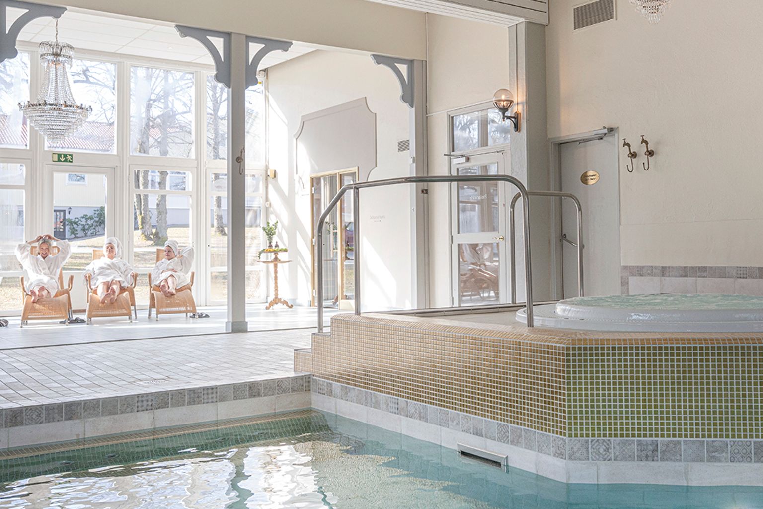 en stor indendørs swimmingpool med et boblebad i midten af det