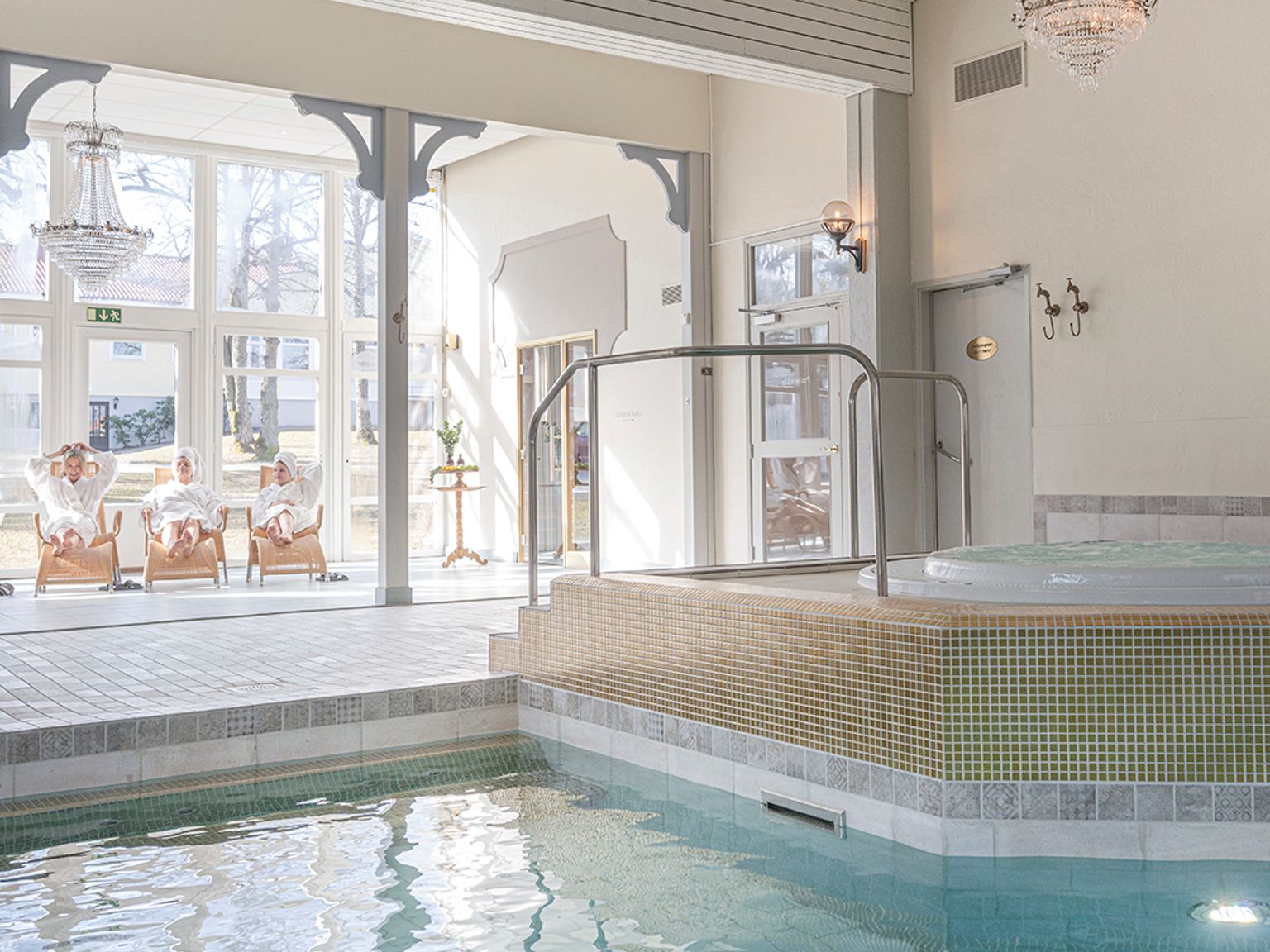 en stor indendørs swimmingpool med et boblebad i midten af det