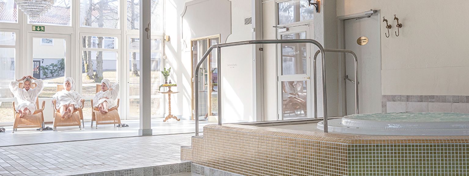 en stor indendørs swimmingpool med et boblebad i midten af det