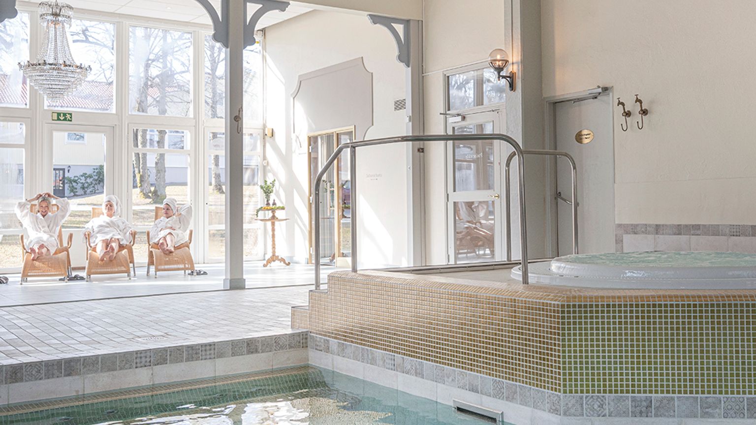 en stor indendørs swimmingpool med et boblebad i midten af det