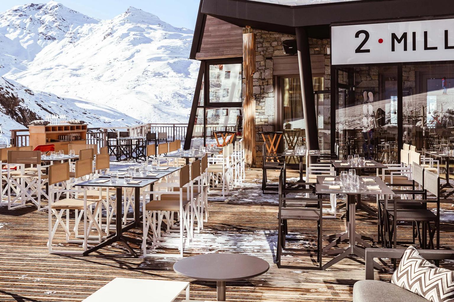 er zijn veel tafels en stoelen buiten een restaurant met bergen op de achtergrond, Altapura Hôtel & Spa Val Thorens.