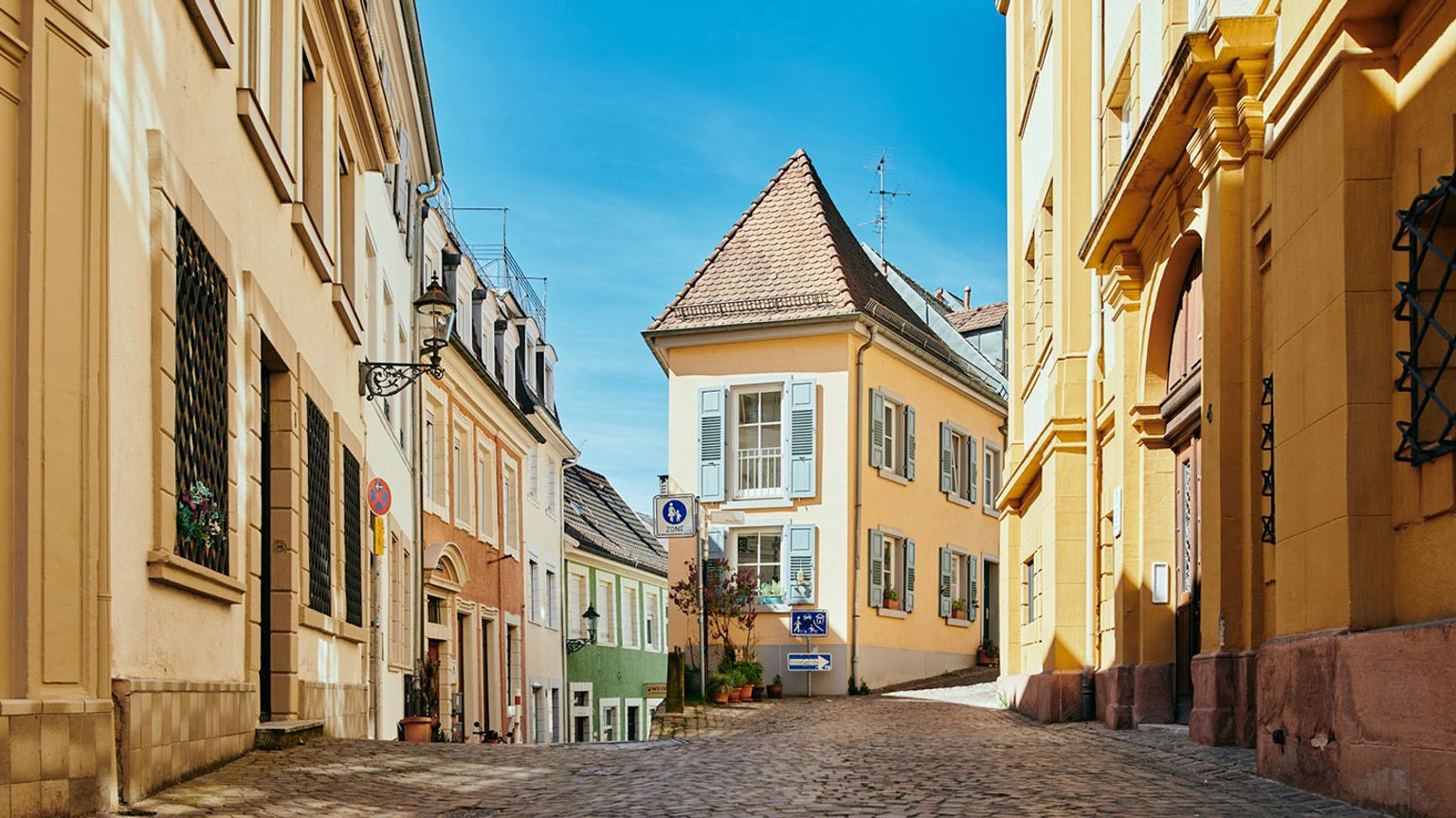 une étroite rue pavée entre deux bâtiments par une journée ensoleillée