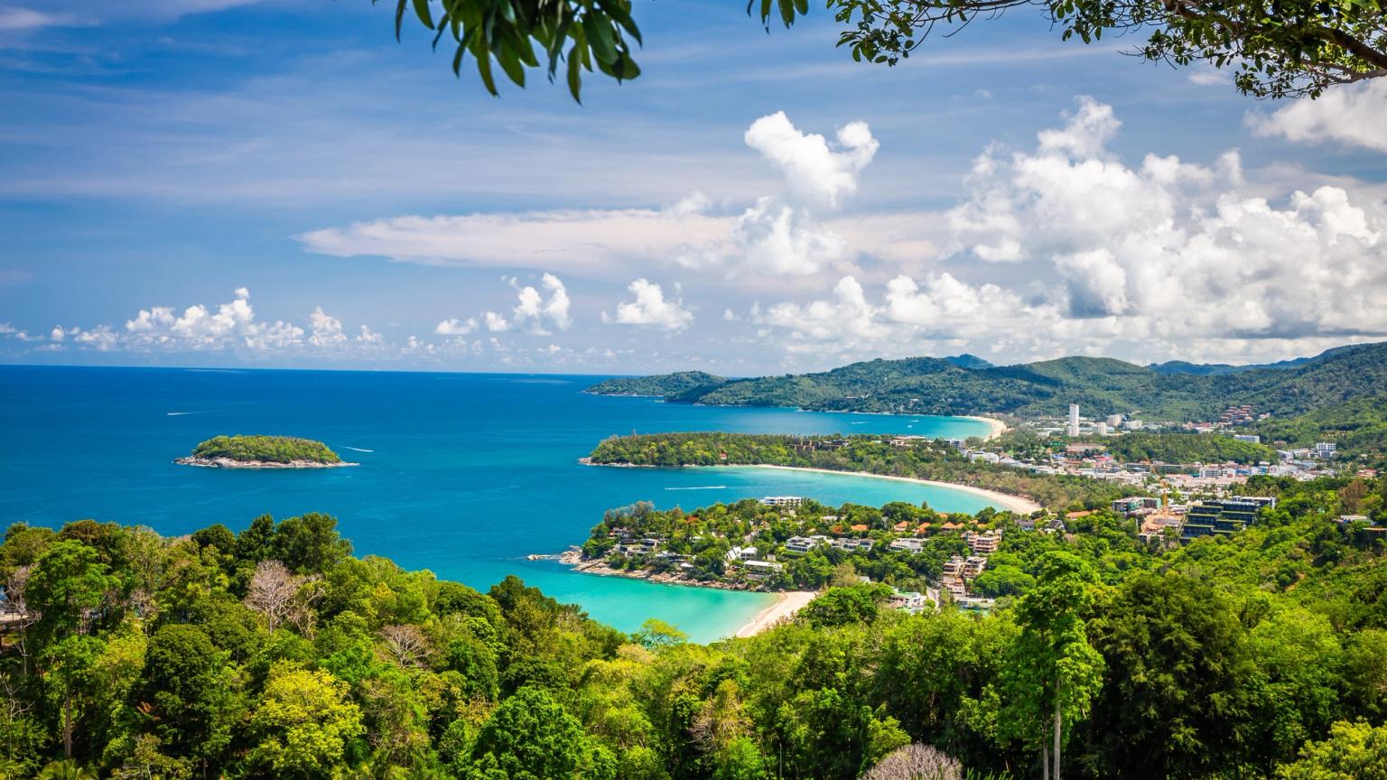 en udsigt til en tropisk strand fra en frodig grøn skov