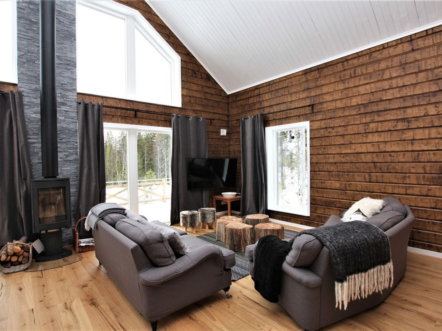 en stue fyldt med møbler og en pejs.