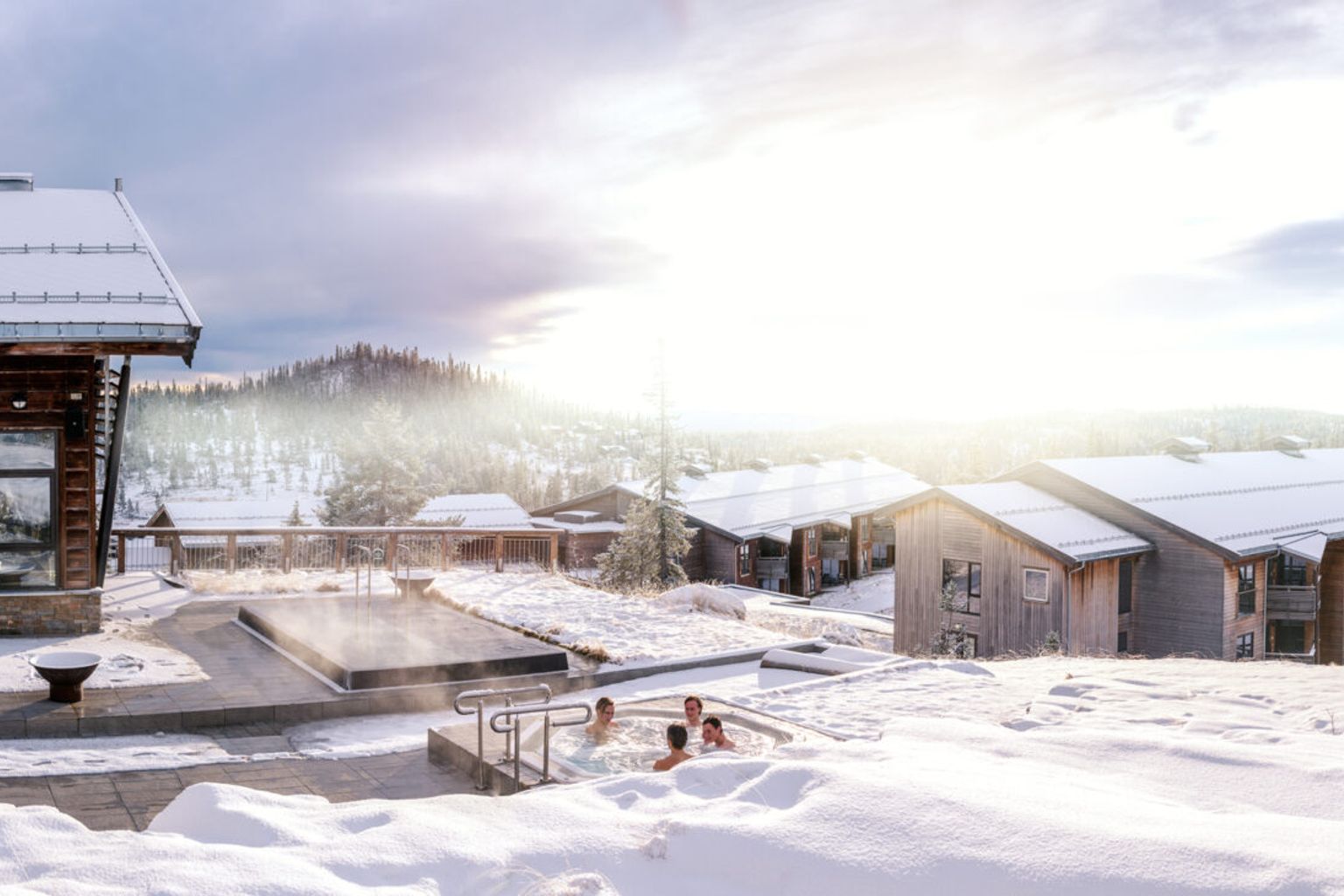 et par personer sitter i et boblebad i snøen.