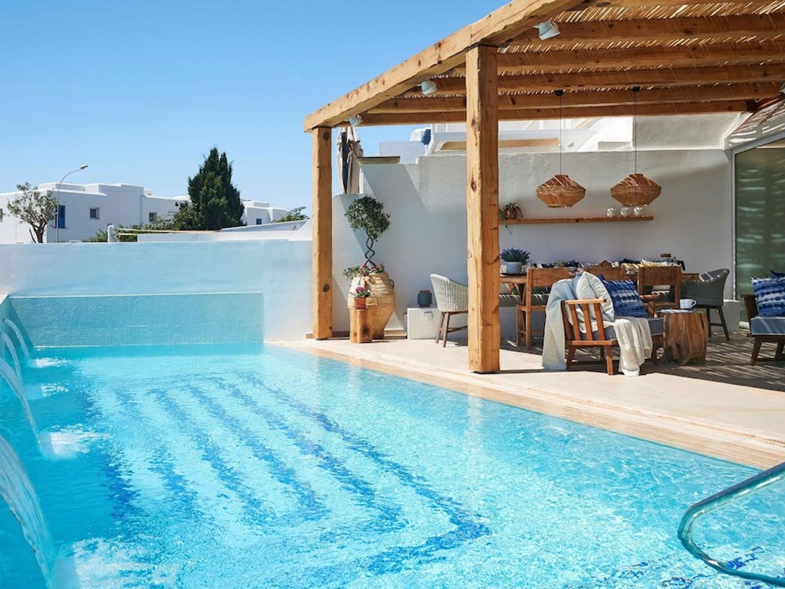 es gibt ein großes Schwimmbecken mit einer hölzernen Pergola darüber.