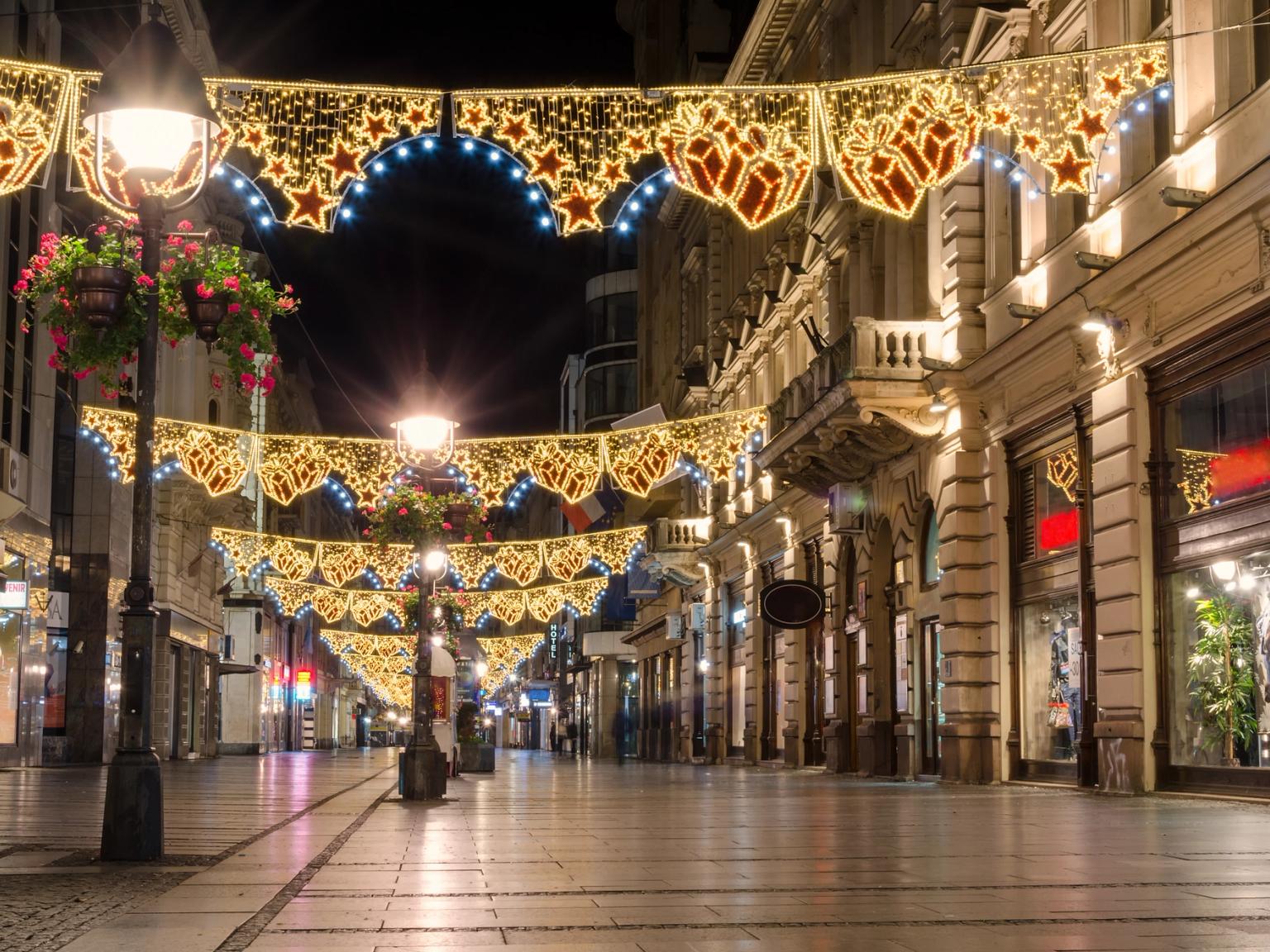 en stadsgata är dekorerad med julbelysning på natten