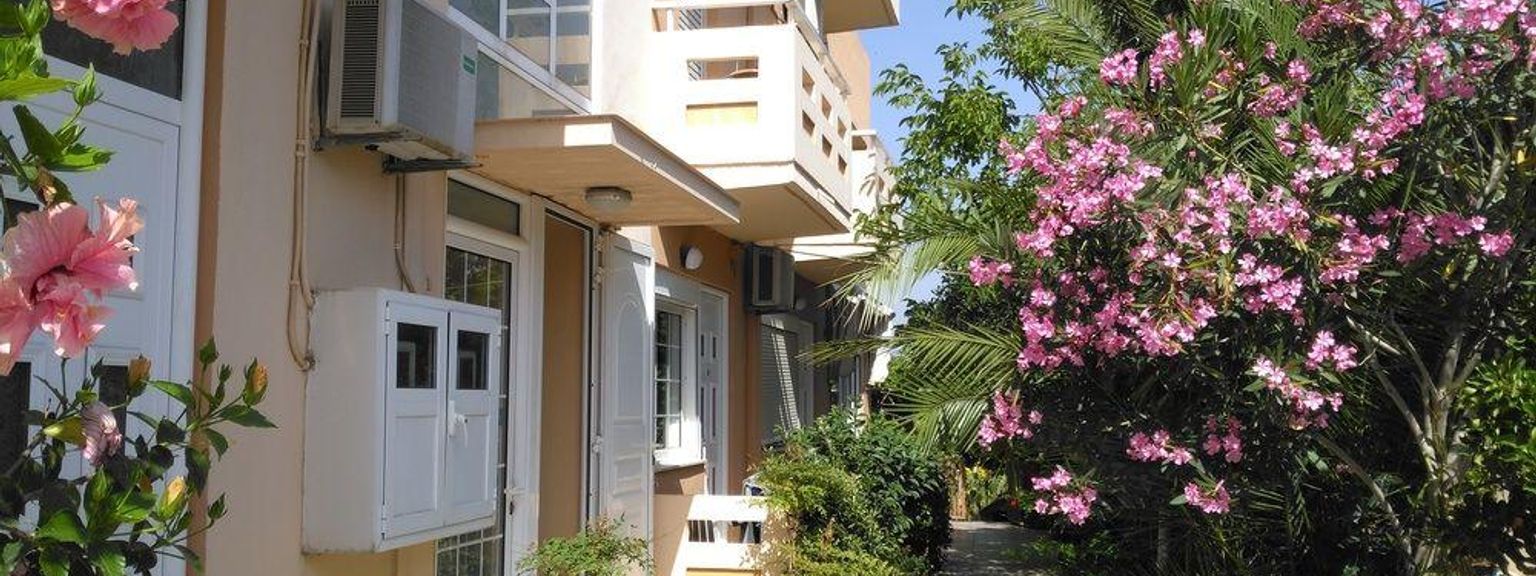 en bygning med mange vinduer og blomster foran den.