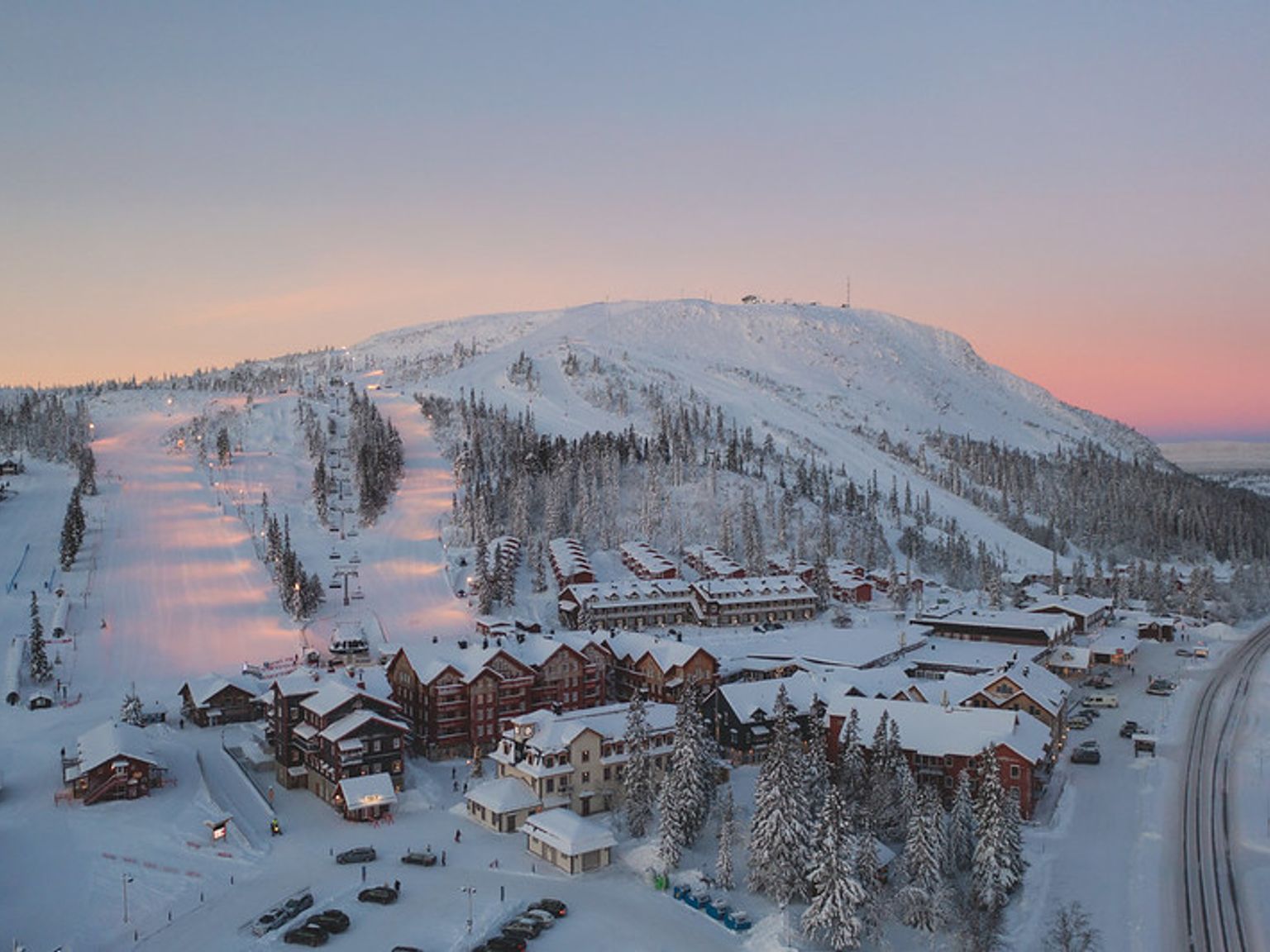 et luftfoto af en snedækket skiresort ved solnedgang