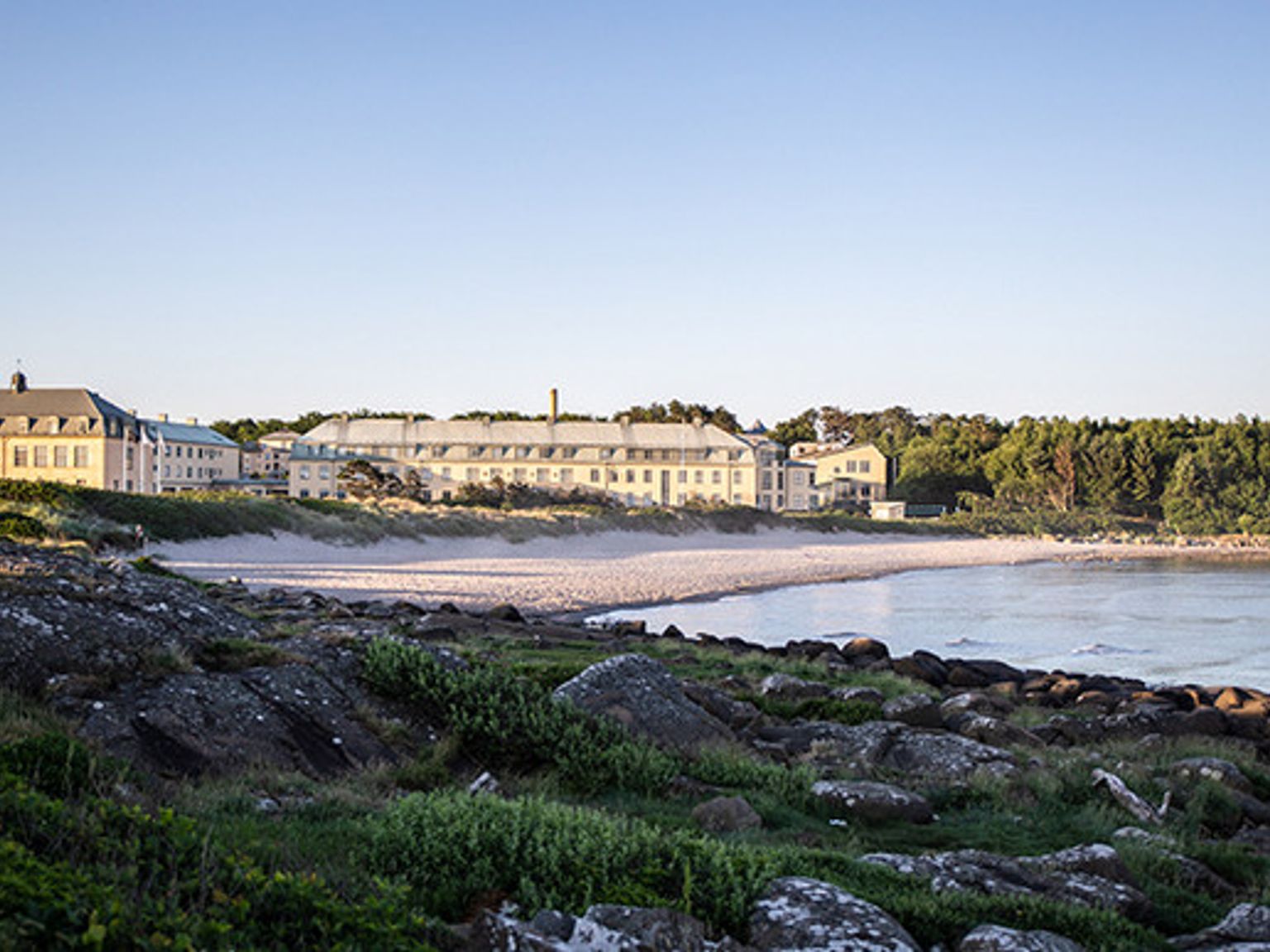 en stor bygning sitter på bredden av en stor vannmasse