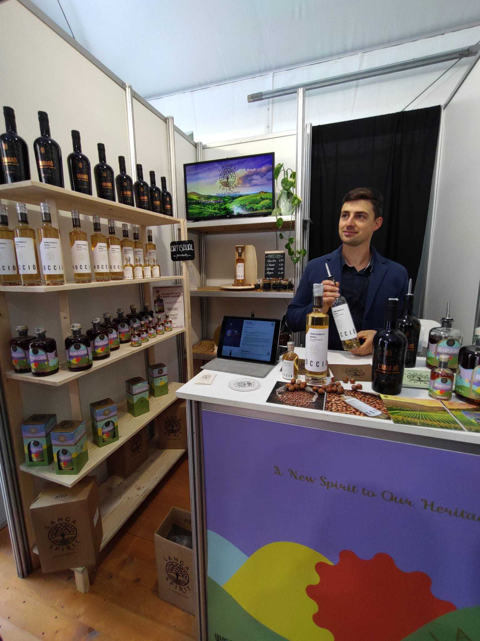 en man står bakom en disk med en flaska cider