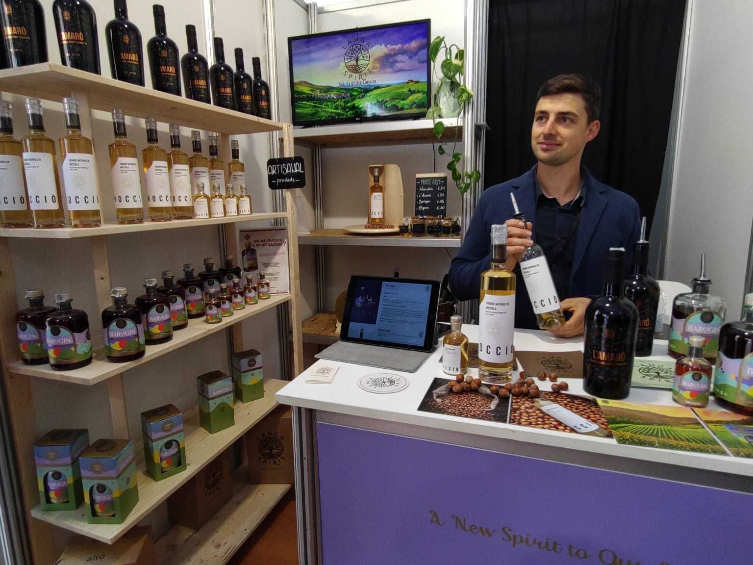 en man står bakom en disk med en flaska cider