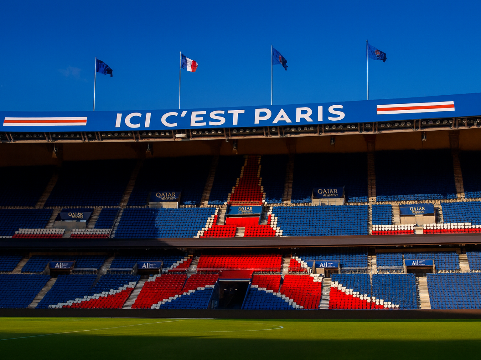 Estádio Parc des Princes vazio com assentos padronizados em azul e vermelho e uma placa "ICI C'EST PARIS".