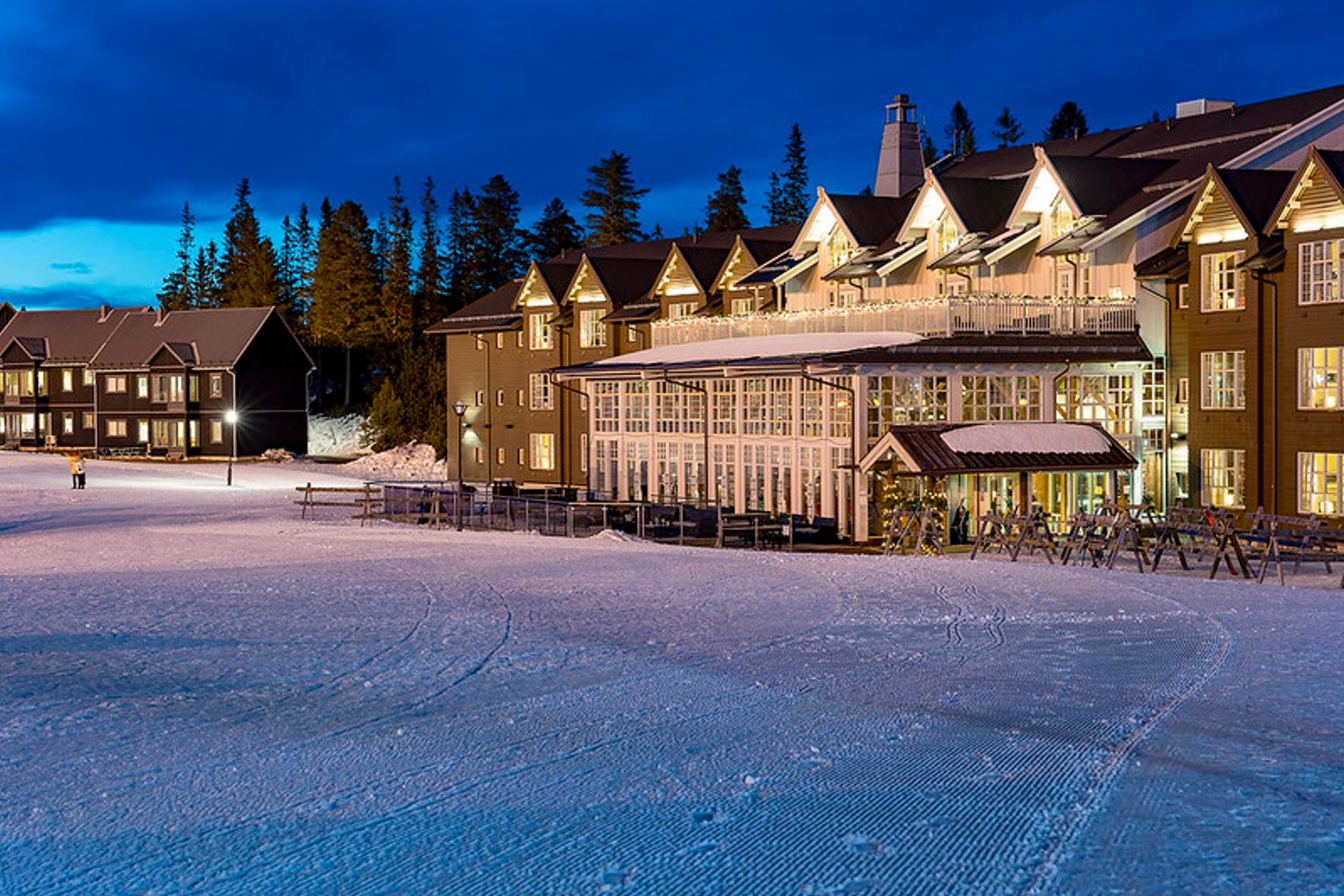 en stor bygning med mange vinduer ligger på en snedækket skråning.