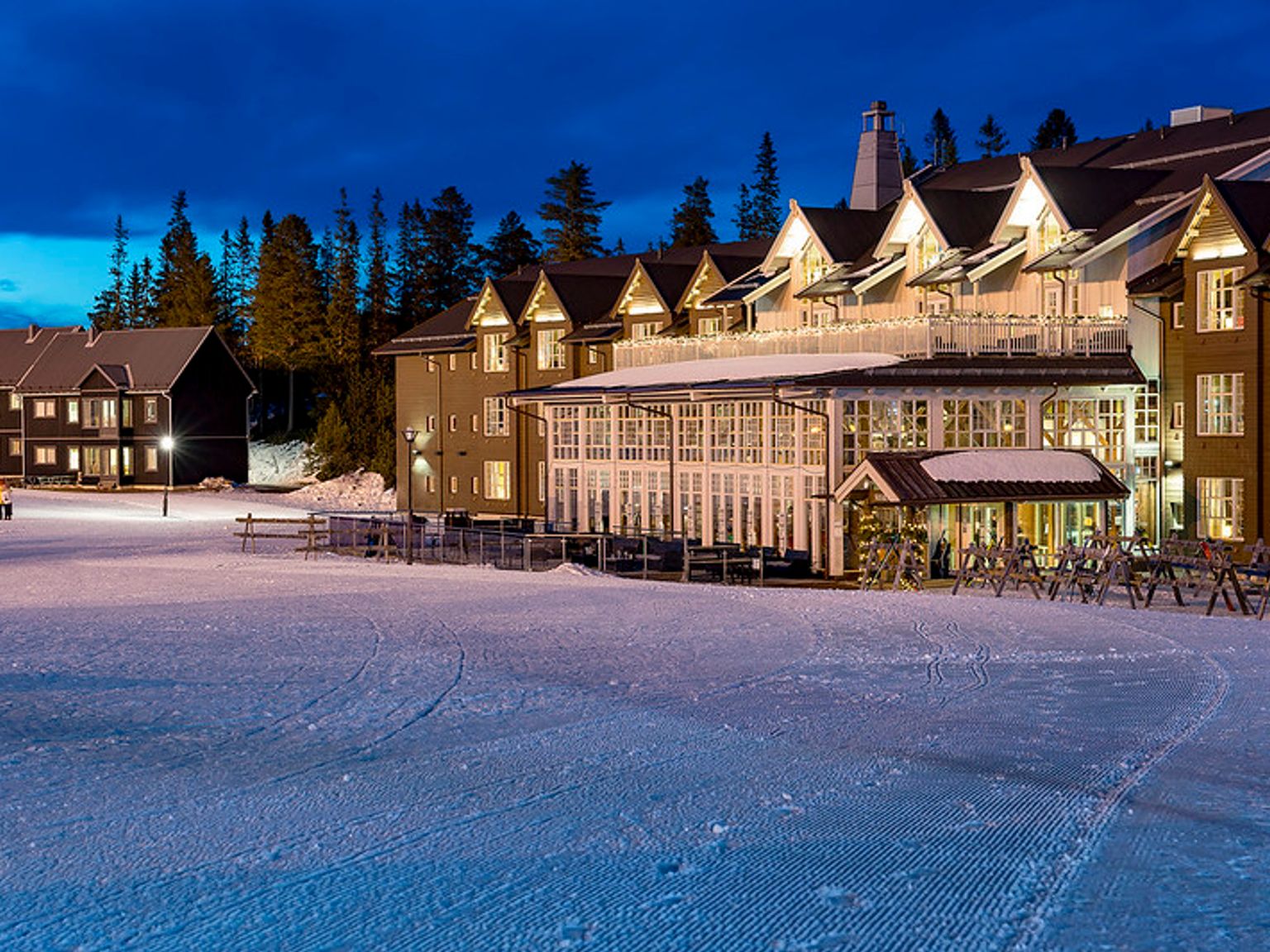 en stor bygning med mange vinduer ligger på en snødekket skråning.