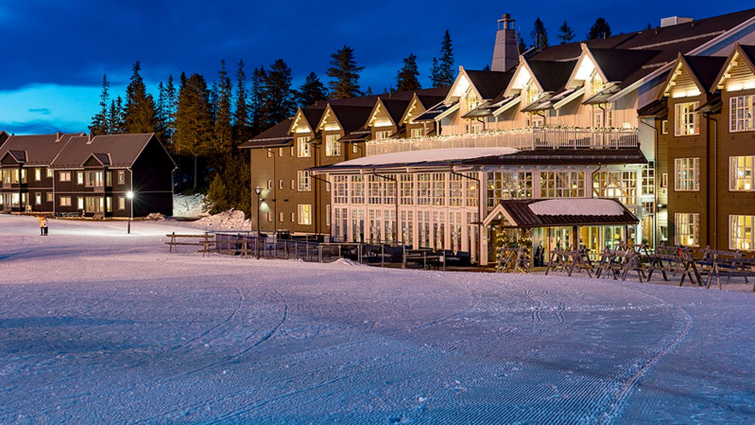 en stor bygning med mange vinduer ligger på en snedækket skråning.