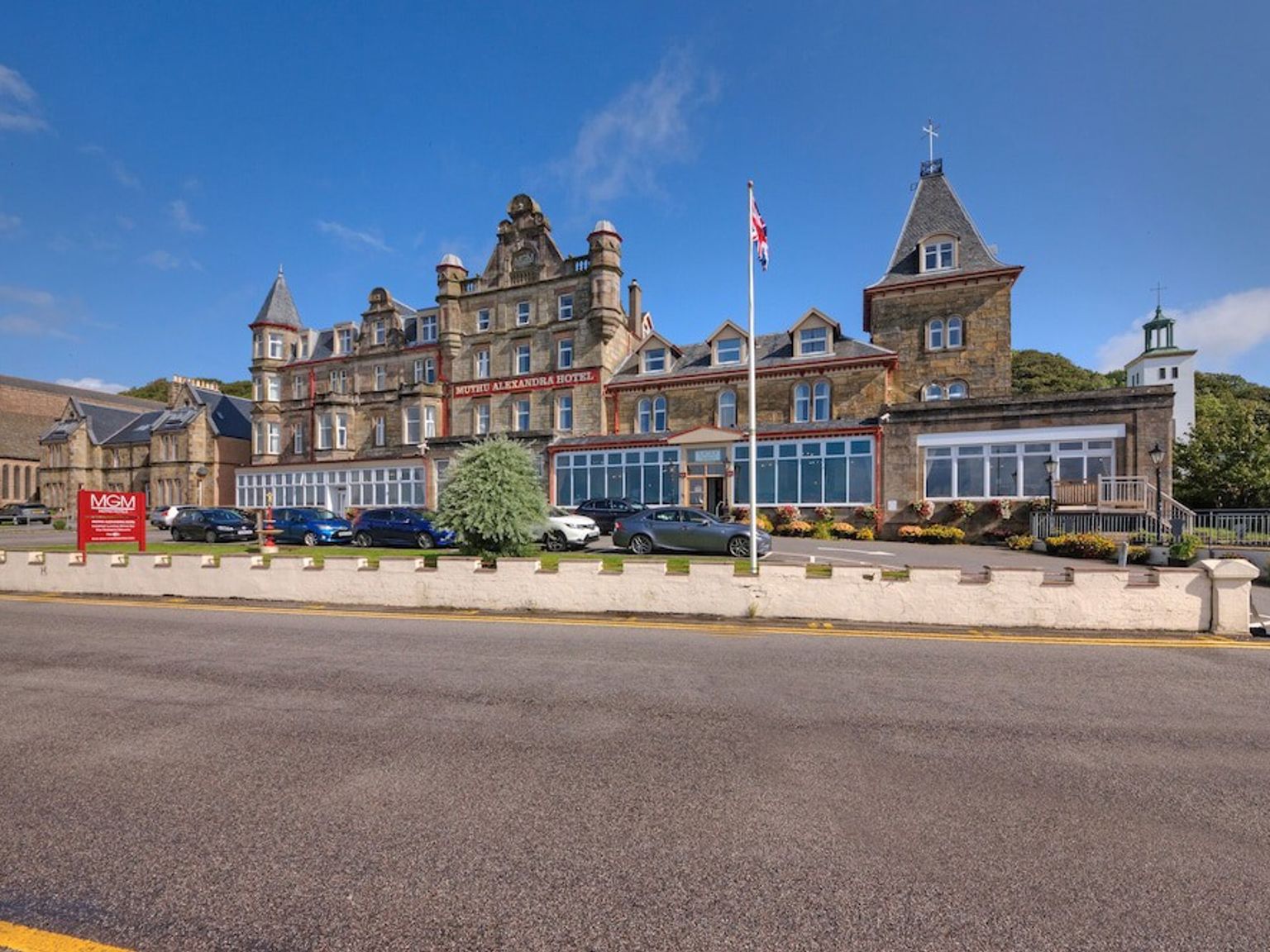 en stor byggnad med många bilar parkerade framför den