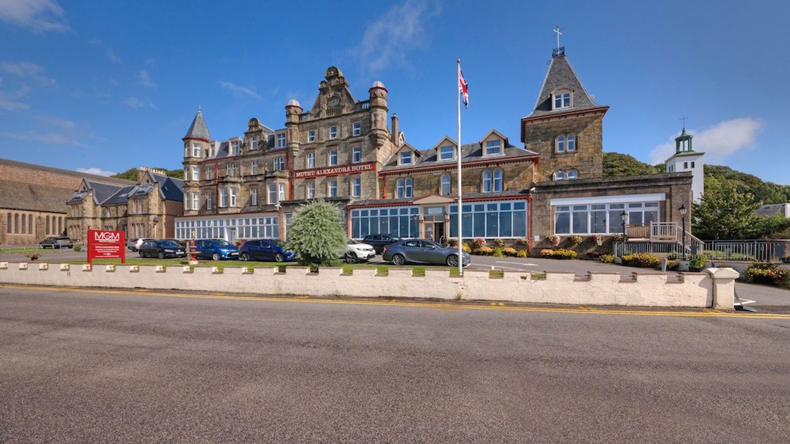 en stor bygning med mange biler parkert foran den