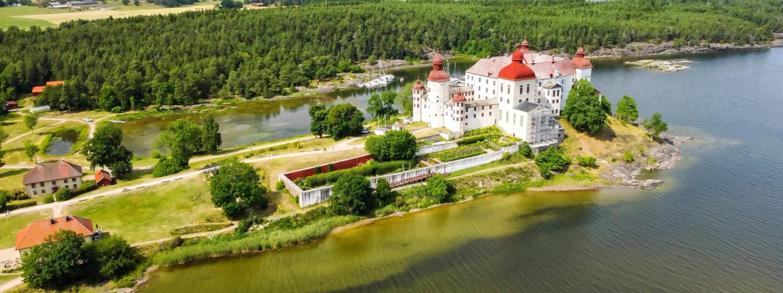 eine Luftaufnahme von einer Burg auf einer kleinen Insel inmitten eines Sees umgeben von Bäumen