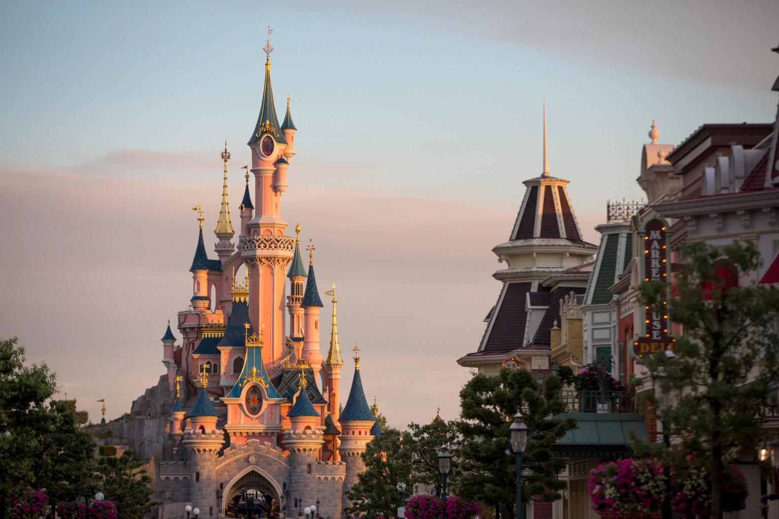 das Schloss ist umgeben von Gebäuden und Bäumen in Disneyland