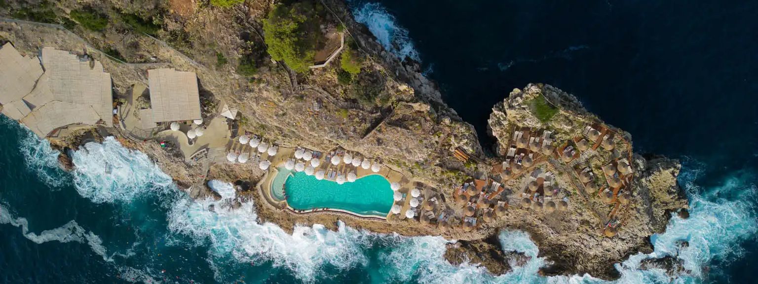 en flygvy av en swimmingpool på en klippa med utsikt över havet, UNAHotels Hotel Capotaormina