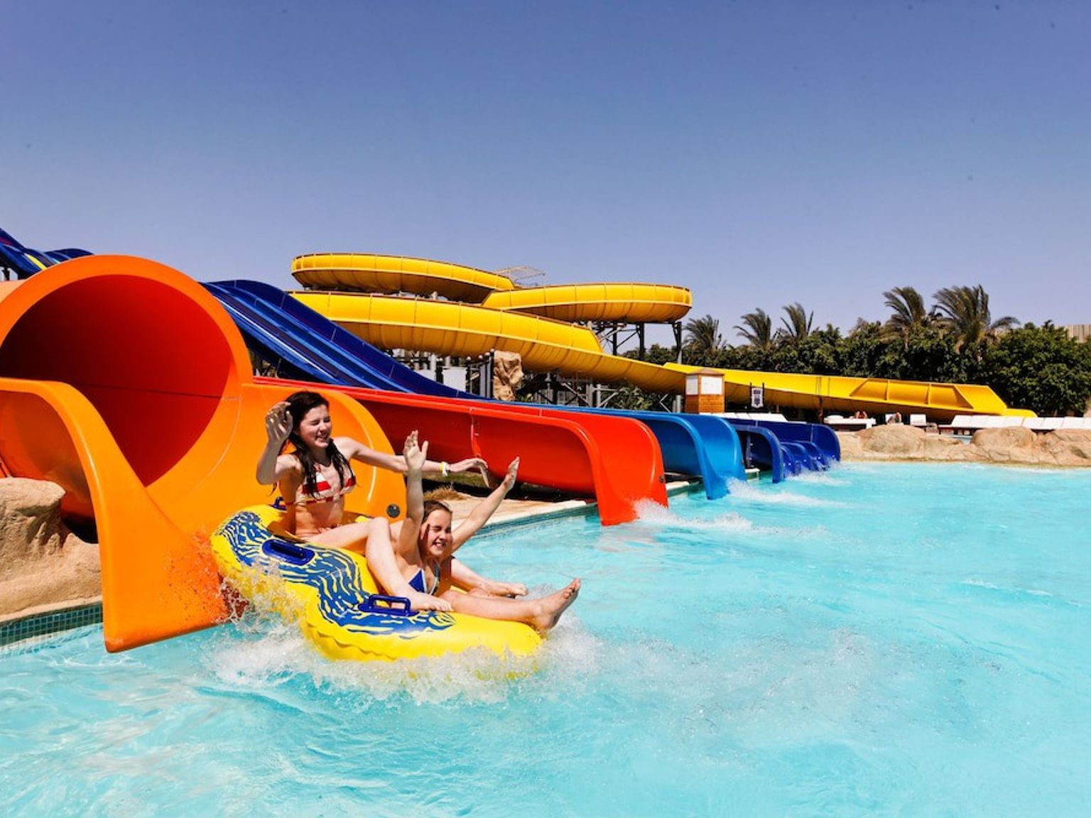 en grupp människor åker ner för en vattenrutschkana på en vattenpark