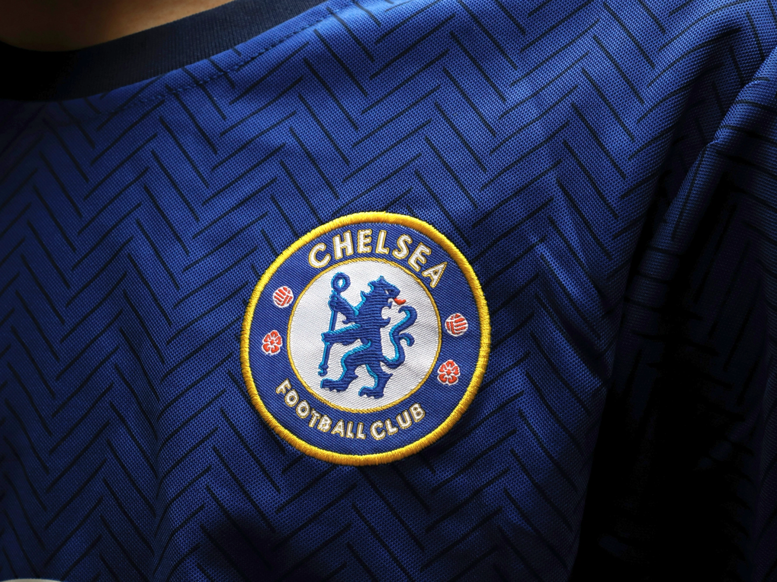 Nærbilde av Chelsea Football Clubs logo brodert på en blå trøye med et sikksakkmønster.