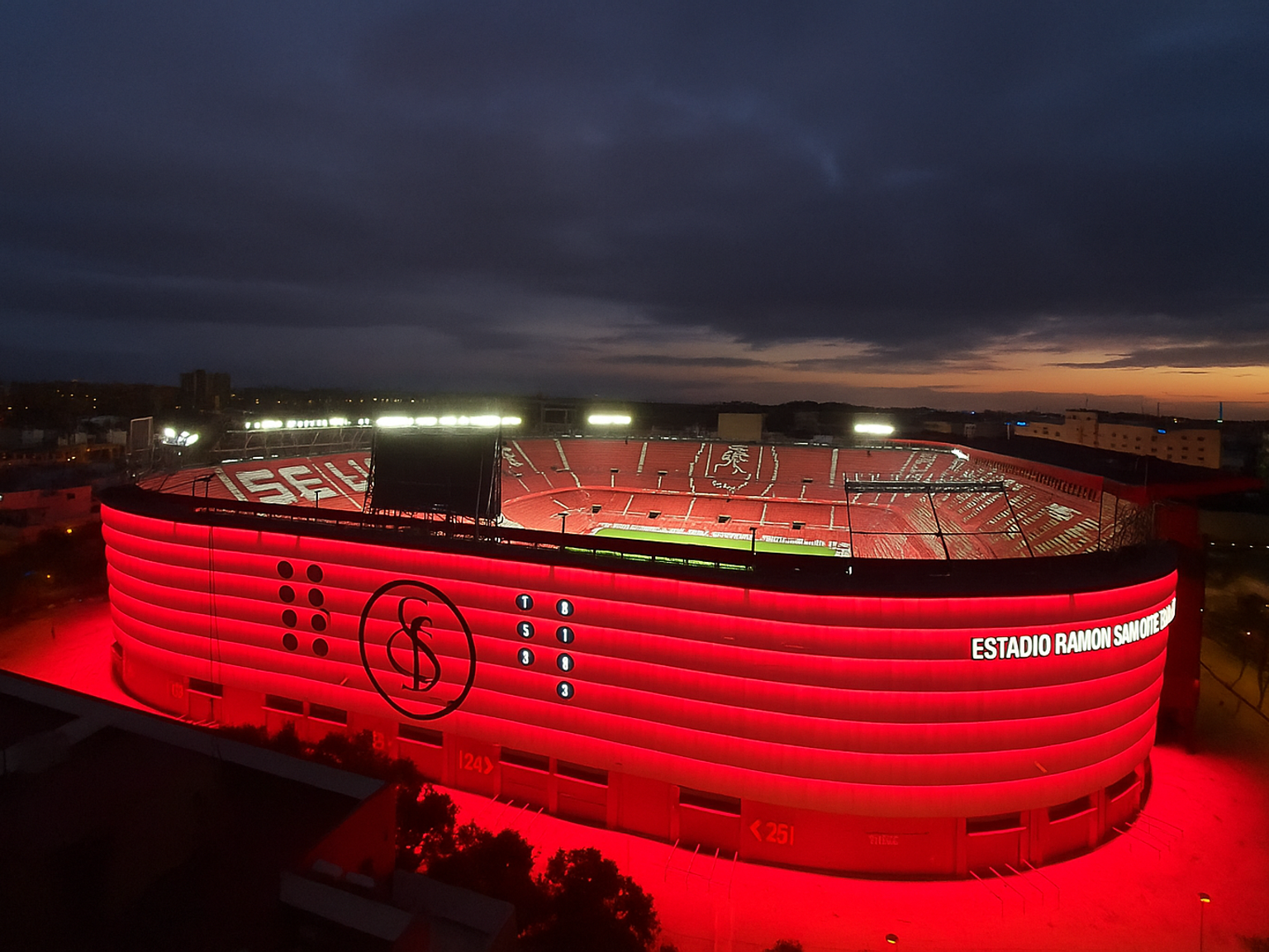 Estadio Ramón Sánchez Pizjuán opplyst i sterkt rødt ved skumring.