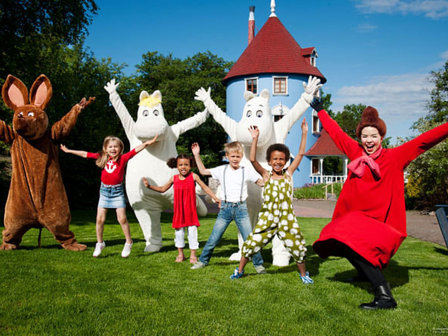 a group of children are posing for a picture with cartoon characters.