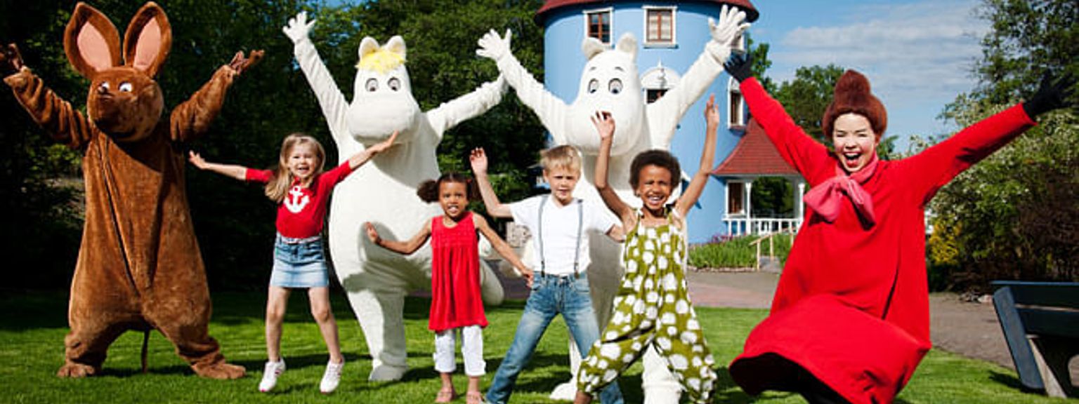 a group of children are posing for a picture with cartoon characters.
