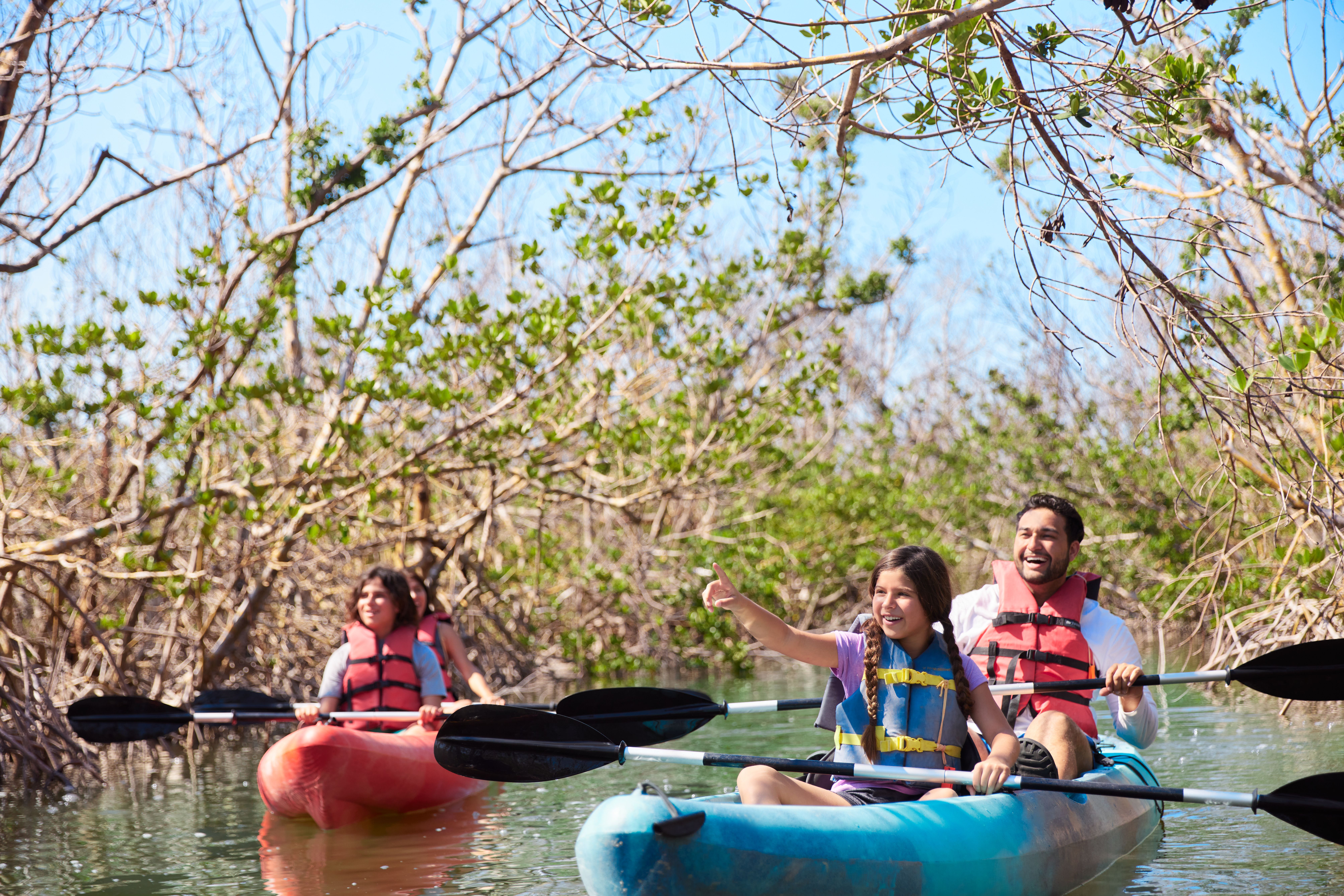 en familie padler kajakker på en elv