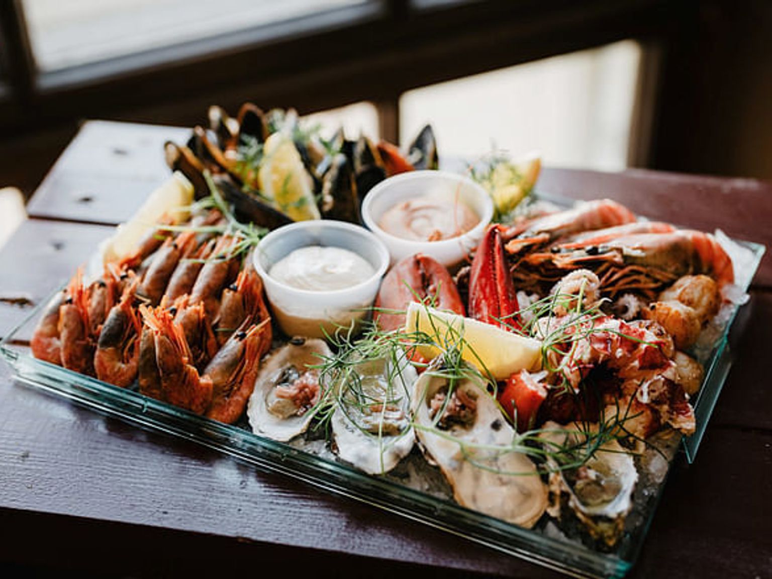 a tray of seafood is sitting on a wooden table