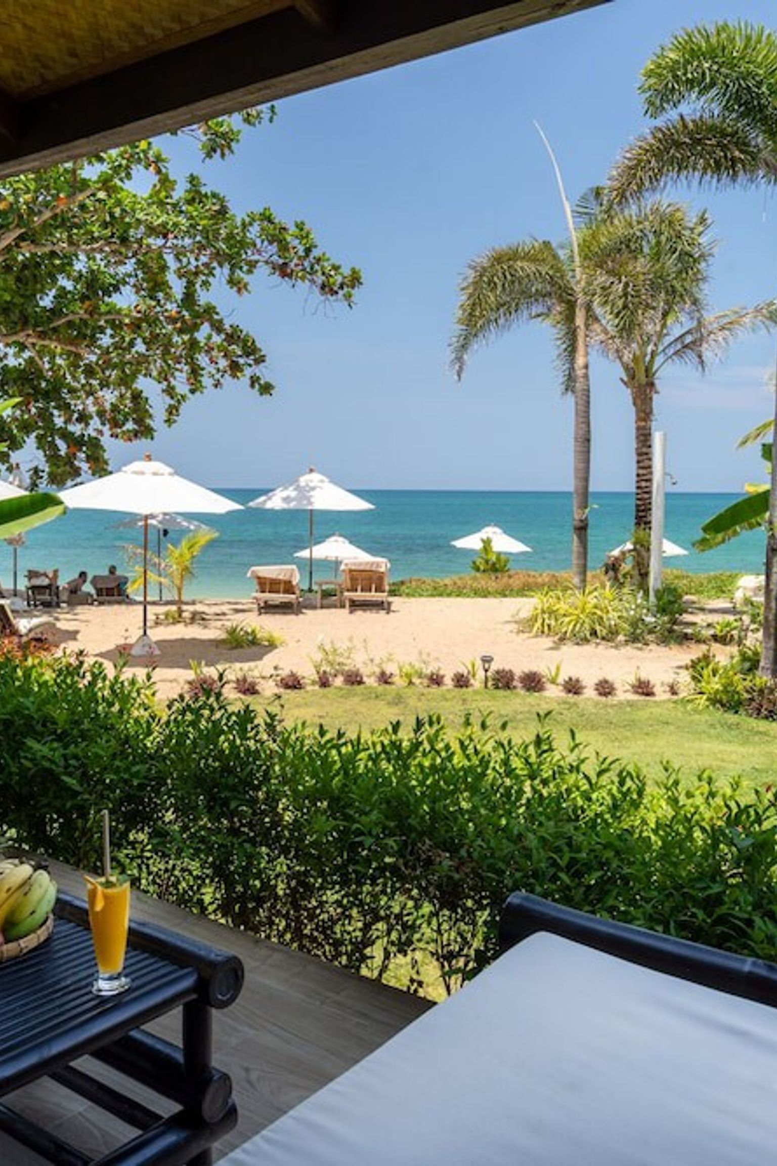 en utsikt över havet från en uteplats med ett bord och stolar