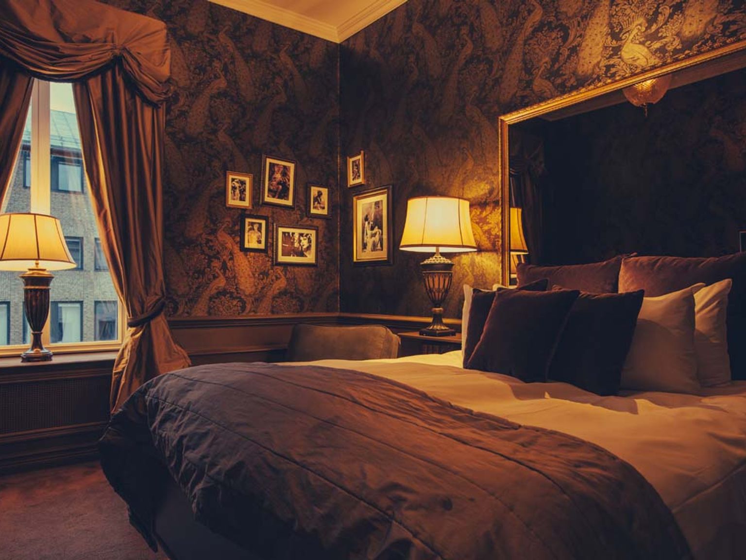 ein Hotelzimmer mit einem Bett, Lampen und Bildern an der Wand