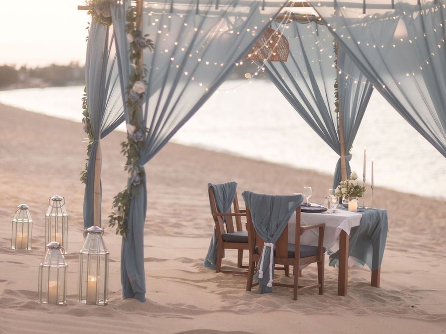 ein Tisch und Stühle unter einem Baldachin am Strand