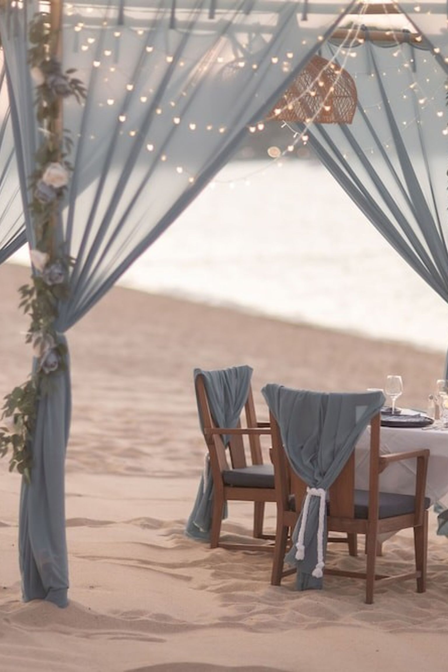 ein Tisch und Stühle unter einem Baldachin am Strand
