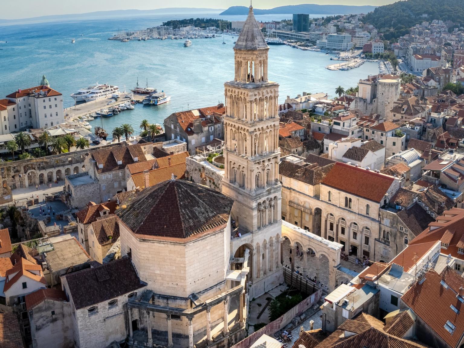 et luftbilde av en by med et stort klokketårn og en stor vannmasse i bakgrunnen. Split, Kroatia