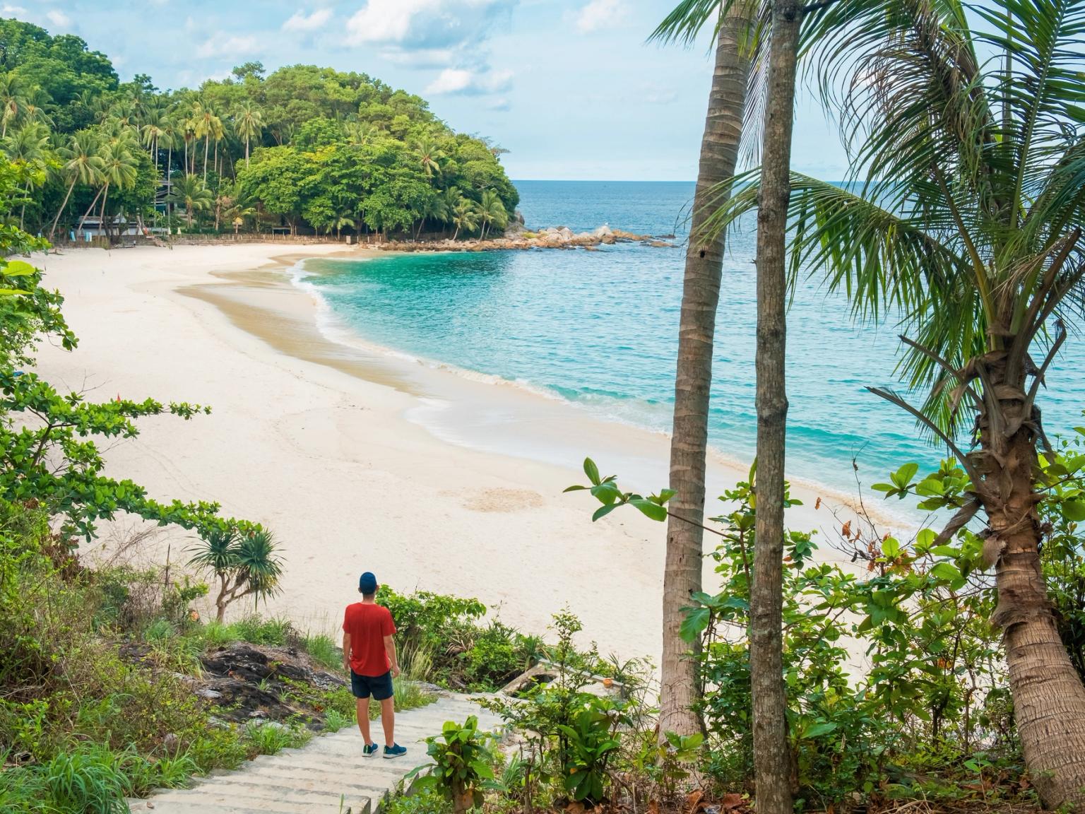 en mann står på en trapp og ser på en strand