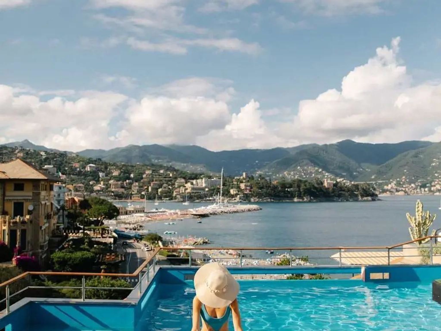 en kvinna i bikini och hatt står i en swimmingpool med utsikt över havet, Hotel Regina Elena