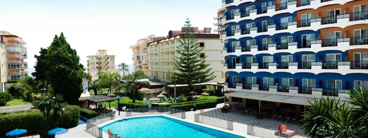 det er et stort svømmebasseng foran et hotell.